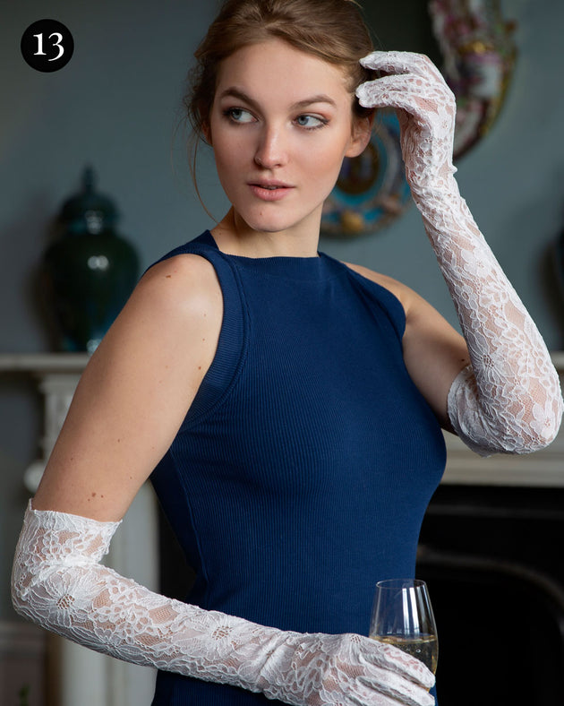 Woman wearing long opera lace gloves in ivory holding a glass of champagne
