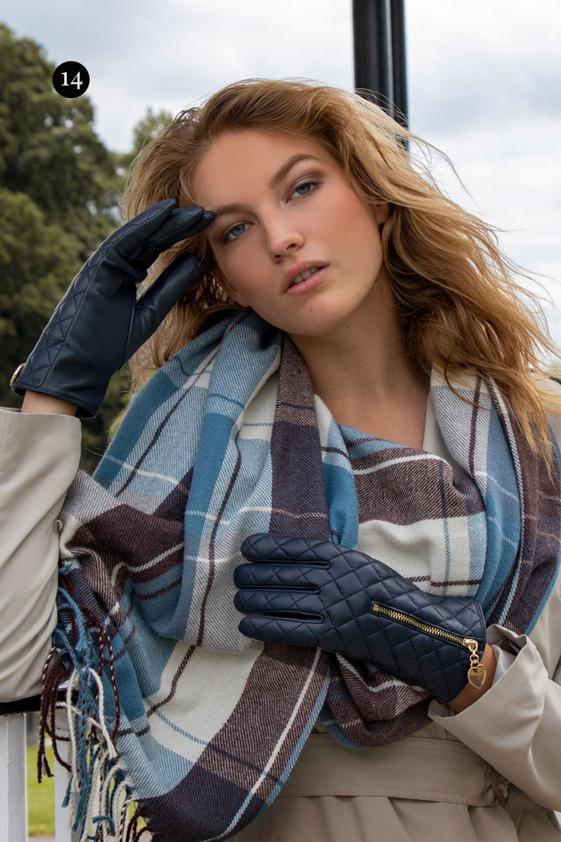 woman wearing navy leather gloves with a zip and a blue/grey check scarf