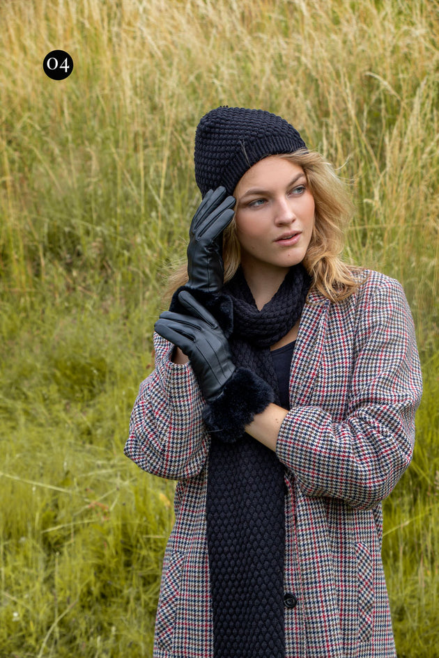 woman wearing black leather gloves with faux fur cuffs and black knitted scarf and hat