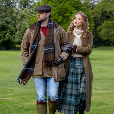 Man and woman wearing leather gloves and checked accessories. 
