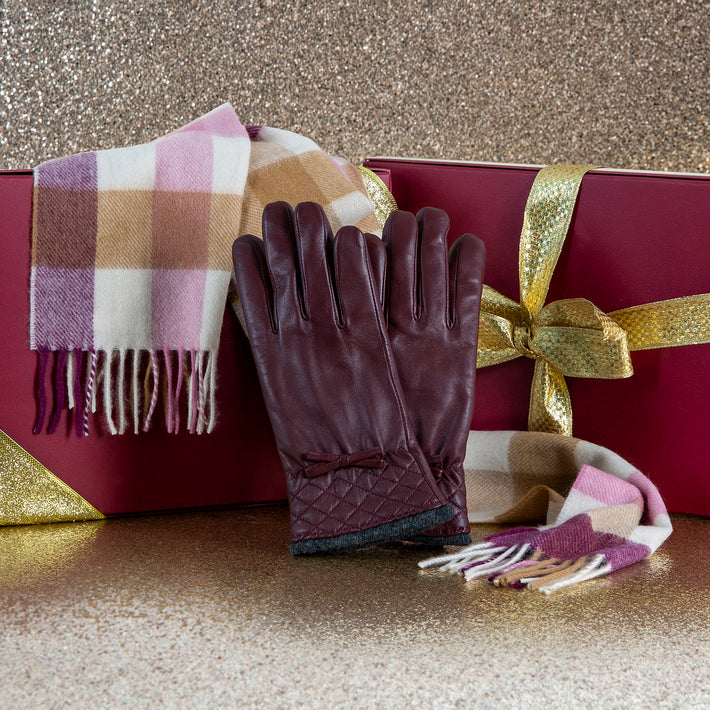 Women's burgundy leather gloves and checked cashmere scarf with Christmas presents