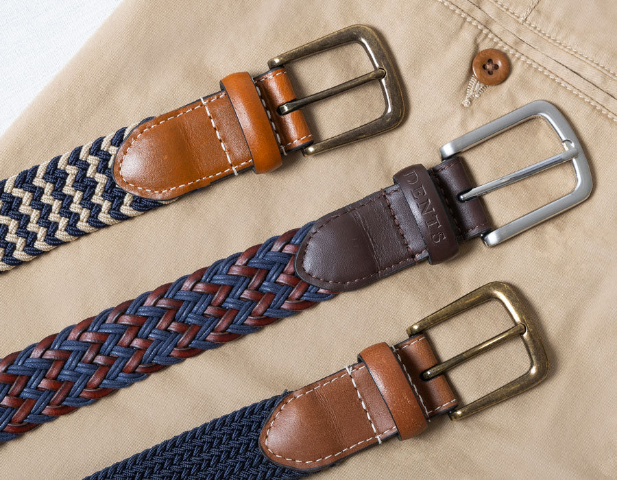 Three woven belts with leather buckles on a beige trousers