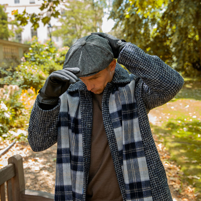 man wearing abraham moon tweed newsboy cap in charcoal walking around the park