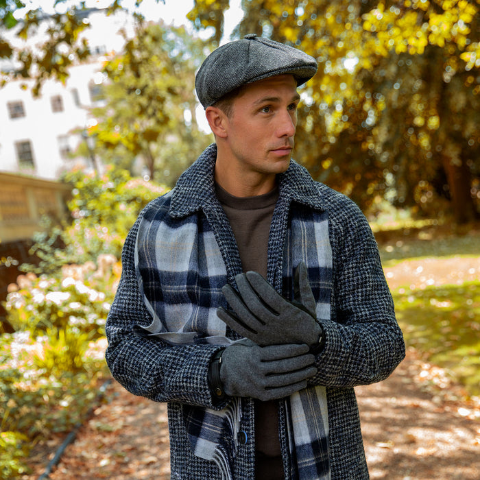 man wearing abraham moon tweed newsboy cap in charcoal walking around the park