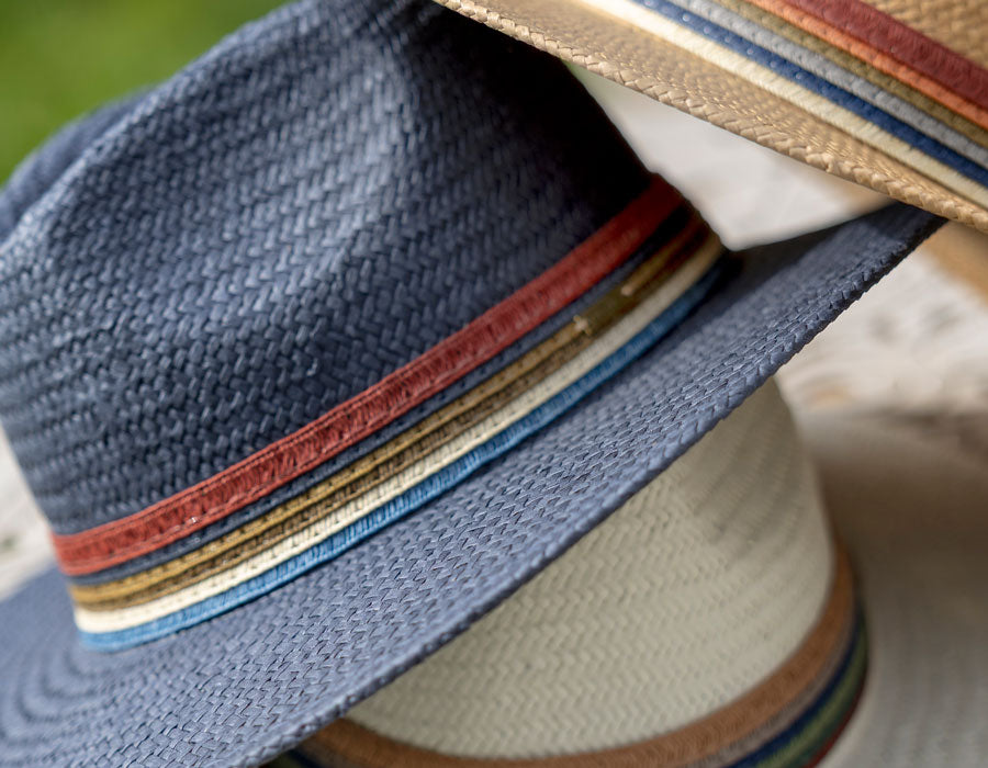 Close-up of a blue straw hat with colorful stripes on a blurred background
