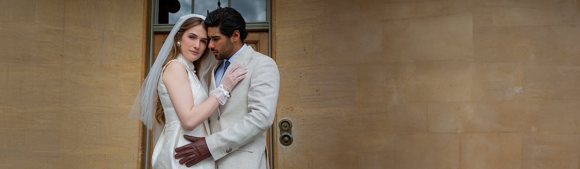 Man and woman getting married wearing spotty tulle gloves with double cuff and decorative bow in white.