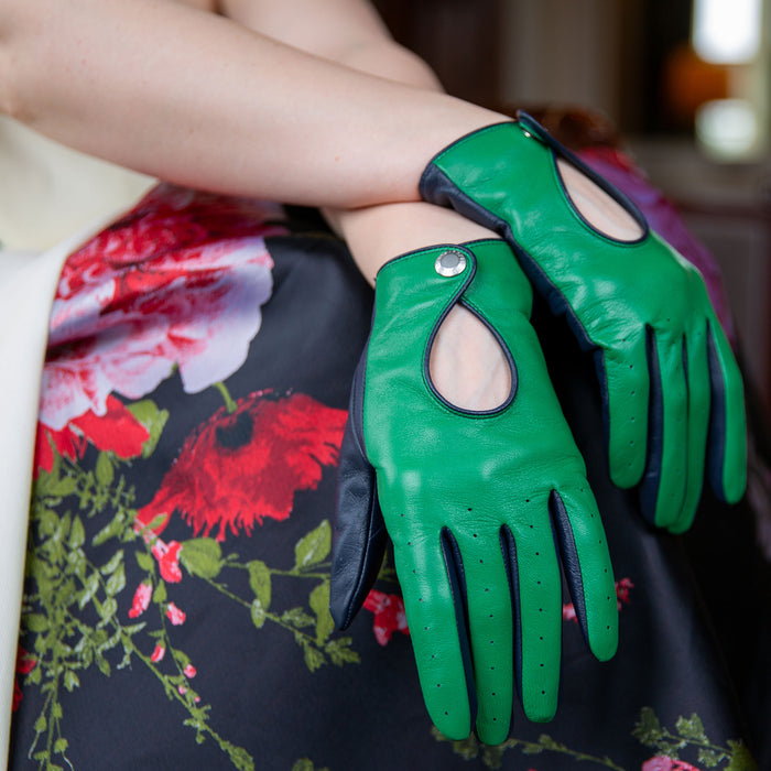 Woman wearing leather touchscreen driving gloves in emerald/navy