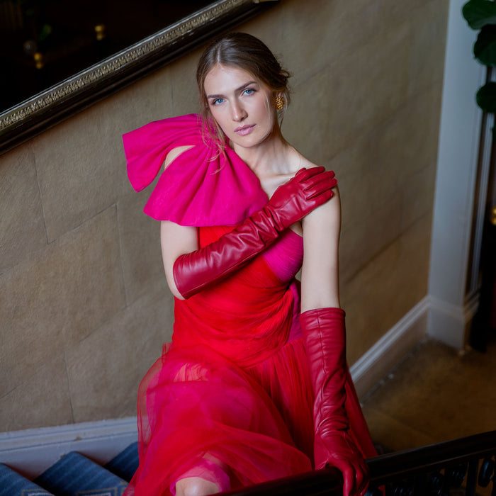 Woman wearing long leather gloves in berry walking up the stairs